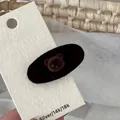 Detailed close-up of a brown flocked bear hair clip on a paper display card - Coffee