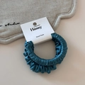 Detailed macro view of dark cyan satin scrunchie with silky texture and handmade tag - Dark Blue