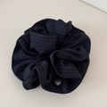 Close-up of black striped scrunchie fabric with a metallic heart-shaped pendant detail - Striped Tie Scrunchie - Navy Blue