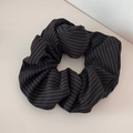 Gros plan d'un chouchou noir oversize à rayures blanches et texture de tissu lisse - Chouchou Rayé - Noir