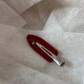 Dettaglio del fermaglio per capelli a forma di ciliegia con strass su sfondo bianco - Rosso