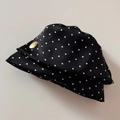 Dettaglio di un fermaglio per capelli nero a pois bianchi con etichetta in metallo dorato - Nero