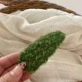 Detailed macro view of the curly green plush lamb wool texture on this cute BB hair clip - Green