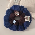 Détail du chouchou en maille avec breloque fleur bleue et écusson pomme mignon - Style Bleu Marine Extérieur Marron Intérieur / Café Et Bleu Marine