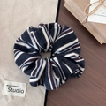 Detail of colorful striped knit scrunchie with soft navy and cream fabric texture - Black