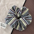 Detailed view of colorful vertical striped oversized scrunchies on rustic fabric background - Gray