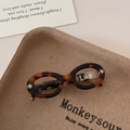 Detail of tortoise shell acetate hair clip in retro oval sunglass design with Like text - Tortoise