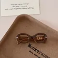 Detail of tortoise shell sunglasses with oval frames on a rustic paper pulp tray - Coffee
