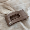 Detalle de una pinza para el pelo con textura de madera y texto Barrette La France dorado - Rectangular Café (FJ892834)