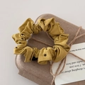 Détail d'un chouchou jaune moutarde à pois sur un emballage de boîte cadeau en papier kraft - Jaune à Pois