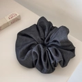 Close-up of a large dark grey fabric scrunchie with detailed twill texture and rich folds - Gray