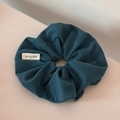 Macro detail of navy corduroy scrunchie fabric with a handmade label and soft texture - Blue