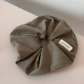 Detailed view of khaki chunky knit scrunchie texture with handmade fabric label - Off-white