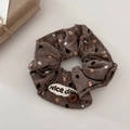 Dettaglio dell'elastico in lino marrone con pois vintage e accento di bottone in legno - Caffè