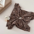 Macro shot of brown polka dot fabric bow hair clip with decorative button and woven label - Coffee Large Scrunchie