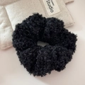 Gros plan du chouchou en peluche noire avec texture en fausse fourrure pour chignon - Noir