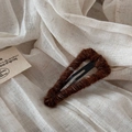 Detailed close-up of brown wool yarn wrapped triangular BB hair clip on linen background - Coffee