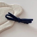 Detailed close-up of a dark blue velvet bow hair clip with a black metal alligator grip - Blue