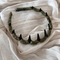 Detail of army green knitted headband featuring black punk spikes and hand made label - Green