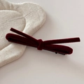 Close-up of a burgundy velvet bow hair clip with a classic metal alligator clip base - Red