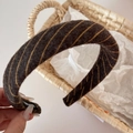 Close-up of thick knitted headband featuring yellow twill stripes and warm wool texture - Brown