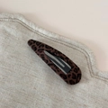 Vue détaillée de la pince à cheveux léopard avec texture floquée brune et base en métal - Léopard Élégant - Pince Goutte d'Eau