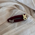 Close-up of a burgundy red velvet hair clip with a cute cartoon bear and white logo detail - Solid Dog Style (Tagi)