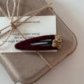 Detailed macro view of burgundy flocked hair clip with cute brown teddy bear and small pearls - Red