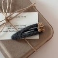 Detailed view of handmade fuzzy bear hair clip with pearl necklace on a gift card - Gray