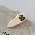 Close-up of a cream-colored teardrop hair clip with a brown 3D flower and green leaf - Off-white