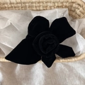 Detail eines handgefertigten schwarzen Samt-Haargummis in Rosenform in einem Korb - Schwarz