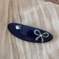 Close-up of a blue acetate oval hair barrette with a gray bow and crystal detail - Blue