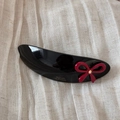 Detail of black acetate hair clip with red bow, rhinestone, and gold Barrette la France text - Black