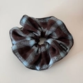 Dettaglio di scrunchie in tessuto a quadretti marrone e blu con etichetta Handmade nera - Plaid Blu Caffè