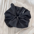 Detail of a large black striped knit hair scrunchie featuring a Hand Made woven label - Scrunchie / Black