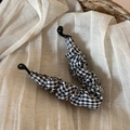 Detail van de vintage zwart-wit geruite gingham stof op een klassieke bananen haarklem - Zwart-wit geruit