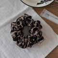 Dettaglio dell'elastico per capelli con stampa leopardata in tessuto 100% poliestere - Stile con Motivo Leopardato Grande