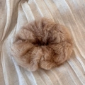 Close-up of soft plush brown scrunchie with fluffy faux fur texture on pleated fabric - Apricot