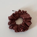 Detalle de coletero de cuero marrón oscuro con clip metálico y textura arrugada única - Coletero de Cuero Marrón