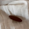 Detail view of large dark reddish-brown glossy hair claw clip on soft beige fabric - Shimmer Coffee - Small Oval Clip