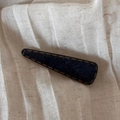 Detail of a navy denim fabric hair clip with yellow stitching on soft linen background - Denim Blue - Triangle Clip