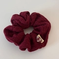 Detailed view of dark red cable knit scrunchie texture with a small plaid fabric label - Cable Knit Scrunchie / Red