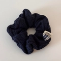 Gros plan d'un bandeau en maille torsadée avec breloque cœur et étiquette tissée - Chouchou en Tricot Torsadé / Bleu marine
