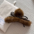 Dettaglio molletta per capelli in peluche marrone con fiocco in pelle su base trapuntata - Giallo