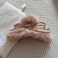Dettaglio molletta per capelli in peluche rosa con fiocco in ecopelle su tessuto morbido - Rosa