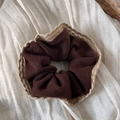 Gros plan d'un chouchou en tricot marron foncé avec bordure en dentelle crème - Chouchou Bord Dentelle