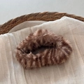 Detail view of large dark brown plush cloud claw clip on a soft woven fabric background - Tiger Stripe Coffee