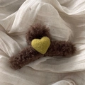 Detail of plush brown wool felt shark hair claw with a green heart and soft texture - Brown