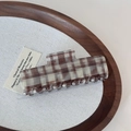 Dettaglio macro della grande molletta per capelli a scacchi marroni su vassoio di legno - Lines Acetic Acid Rectangular Grip - Brown
