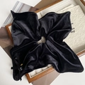 Detailed view of luxury black velvet scrunchie with silk ribbon bow and gold metal charm - Black